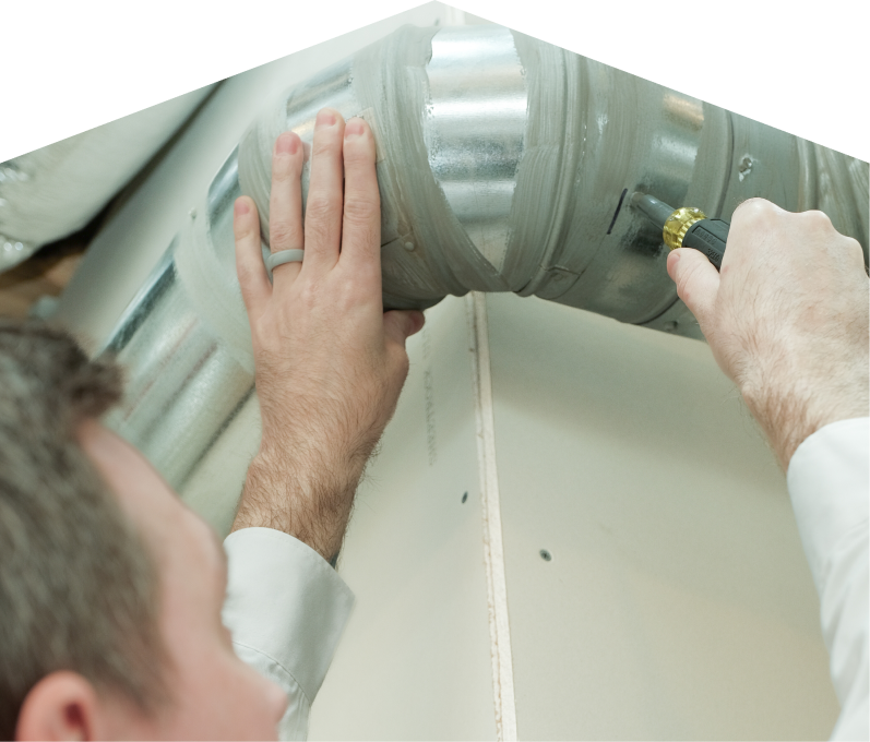 Peel HVAC technician inspecting and tightening a joint on a sealed metal air duct, performing maintenance work during an air duct cleaning task. Peel HVAC technician inspecting and tightening a joint on a sealed metal air duct, performing maintenance work during an air duct cleaning task.