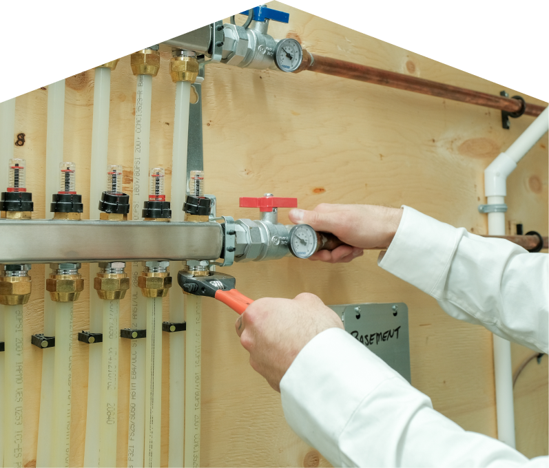 Peel HVAC specialist performing boiler repair, adjusting internal components of a residential unit with visible copper piping and control wiring. Peel HVAC specialist performing boiler repair, adjusting internal components of a residential unit with visible copper piping and control wiring.