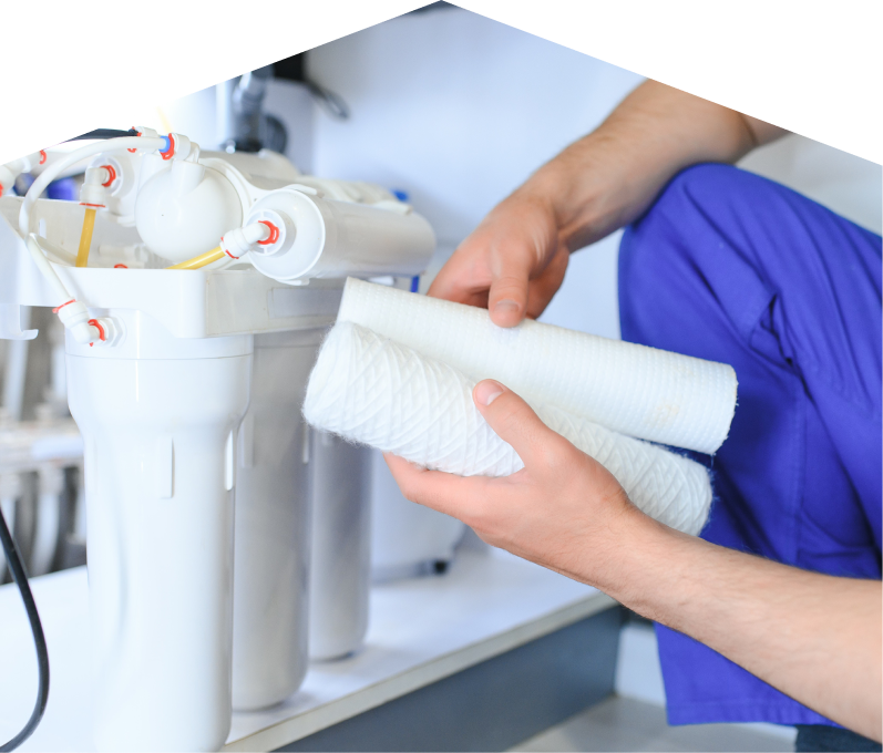 Peel water filtration specialist replacing filter cartridges on a reverse osmosis water system installed under a sink. Peel water filtration specialist replacing filter cartridges on a reverse osmosis water system installed under a sink.