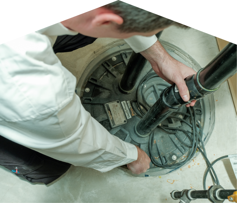 Peel sump pump specialist secures discharge piping on a sealed basin during a sump pump installation in a basement utility area. Peel sump pump specialist secures discharge piping on a sealed basin during a sump pump installation in a basement utility area.