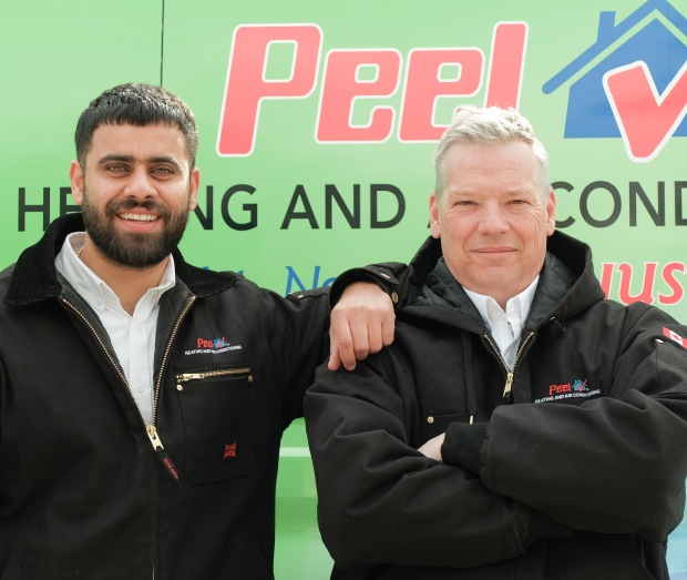 Smiling Peel technician standing confidently in front of their green service van, wearing their white issued uniform. Smiling Peel technician standing confidently in front of their green service van, wearing their white issued uniform.