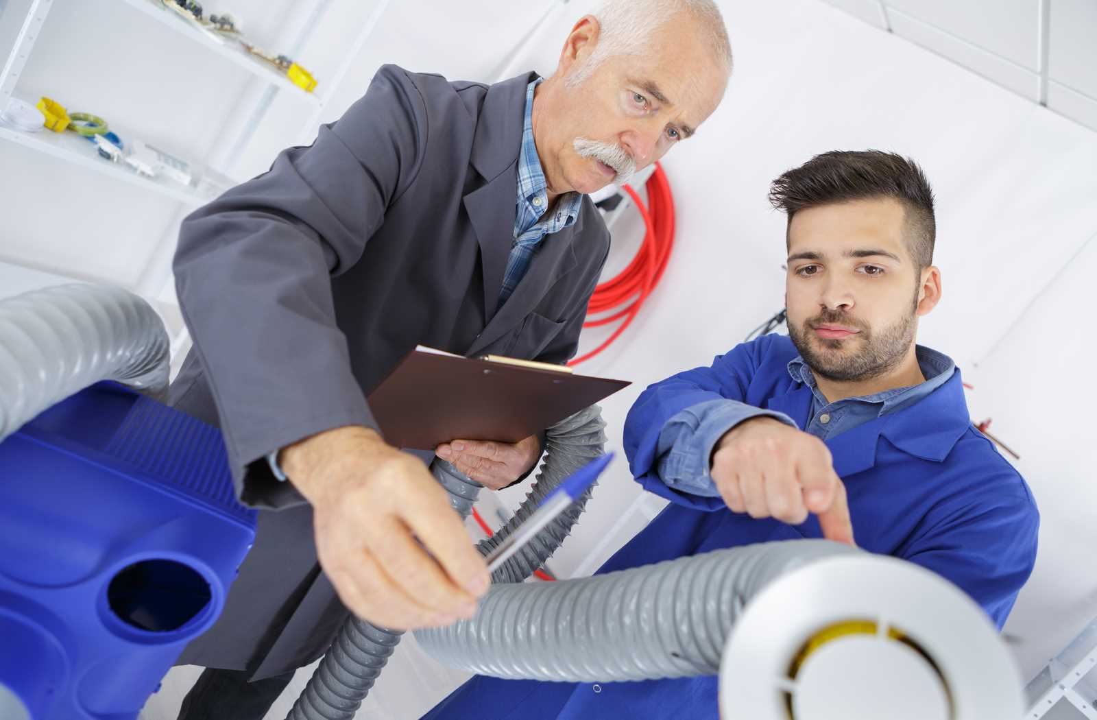 two men inspecting ventilation hose