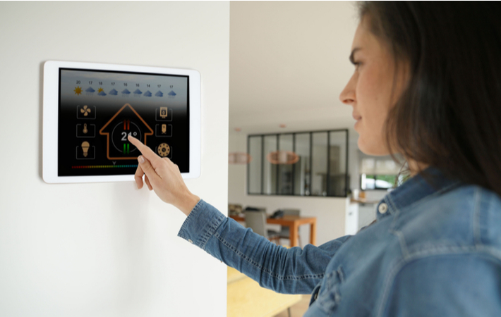 woman using the touchscreen on an advanced thermostat